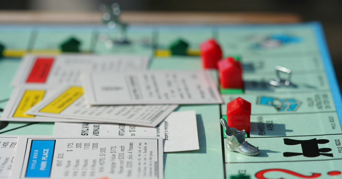 Fichas y propiedades del juego Monopoly como metáfora visual de la concentración de mercado y el poder económico.